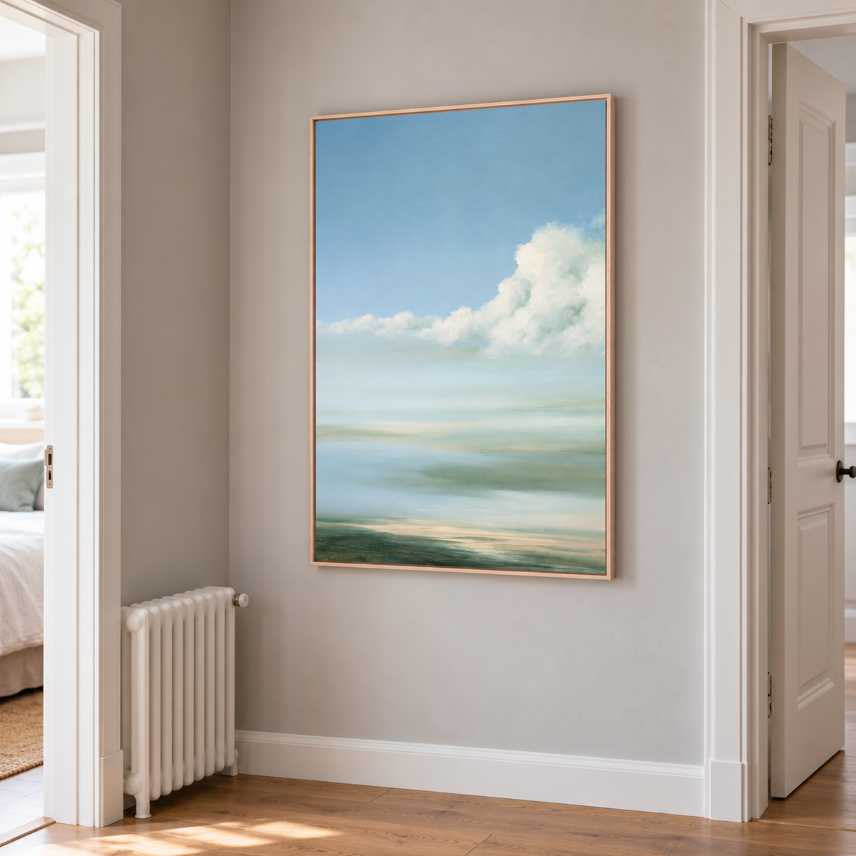 Ciel bleu et nuage blanc en cadre chêne clair dans un couloir, accroché près d'une porte et d'un radiateur blanc