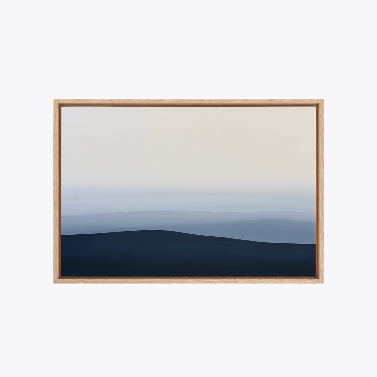 Tableau déco collines bleues encadré en chêne clair, vue de face, horizon brumeux et grand ciel crème