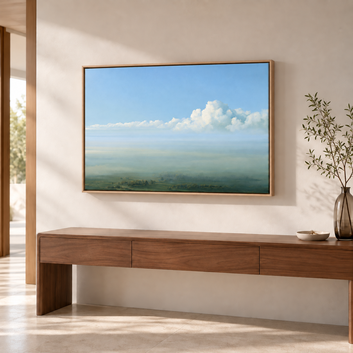 Paysage ciel bleu en cadre chêne clair au-dessus d'une console suspendue en noyer, près d'une baie ouverte