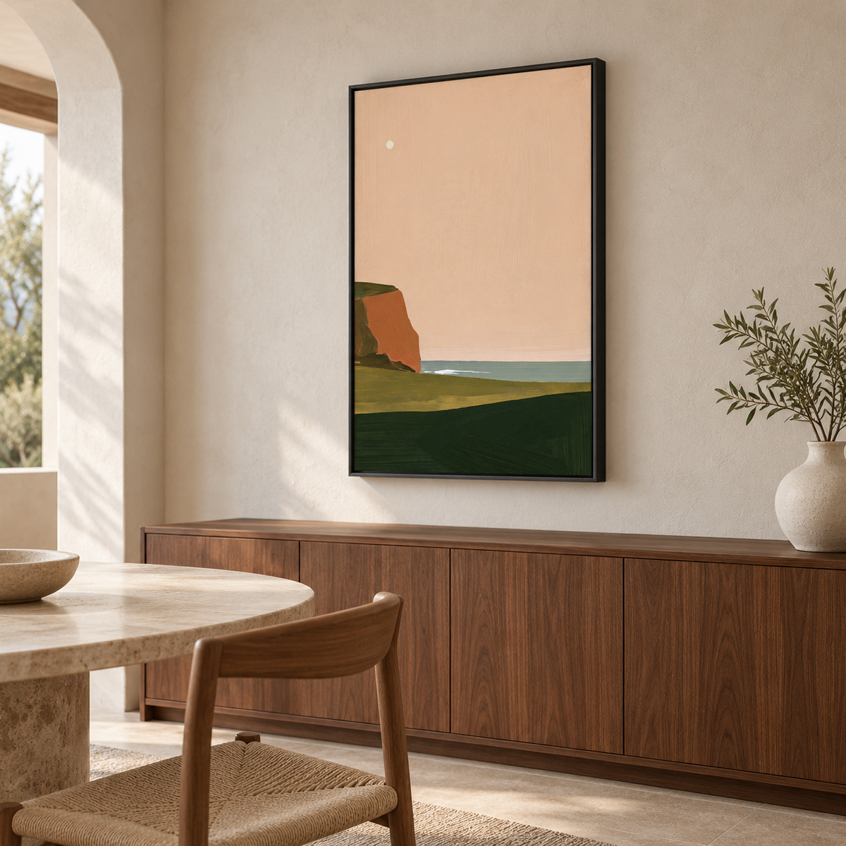 Tableau salle à manger en cadre noir, paysage côtier rose et vert au-dessus d'un buffet en noyer
