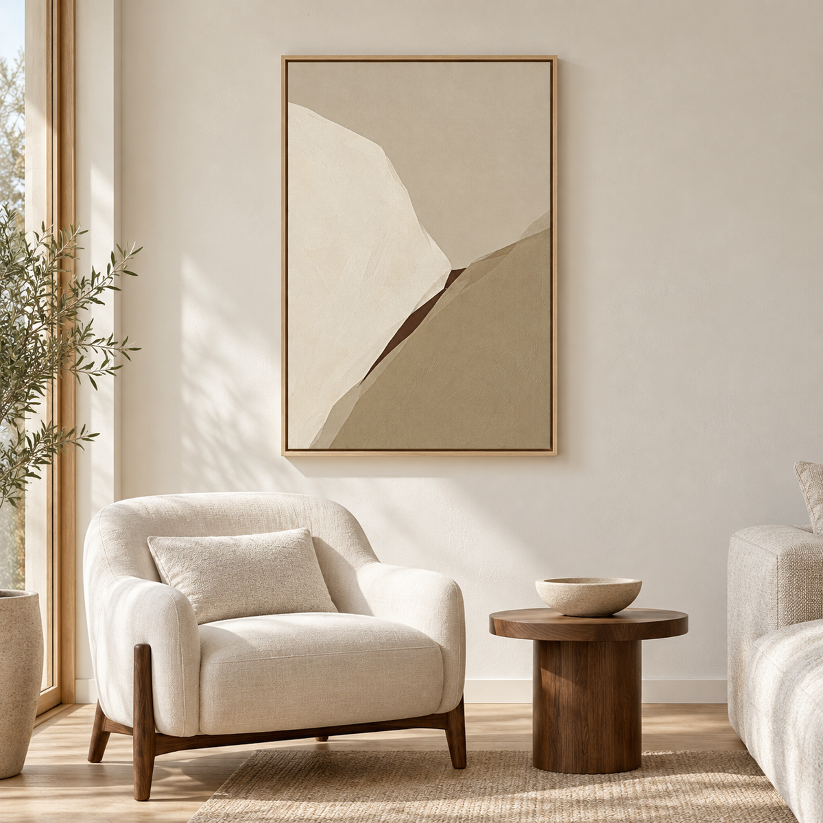 Tableau déco salon en cadre chêne clair, abstrait beige et taupe au-dessus d'un fauteuil bouclé crème
