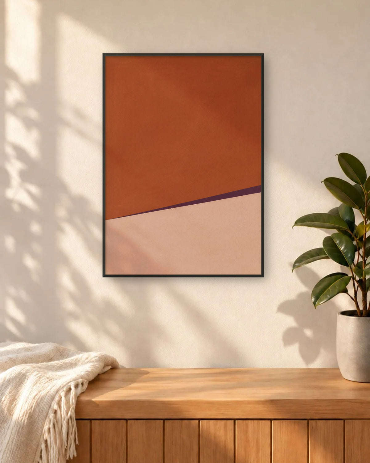 Affiche entrée terracotta et rose en cadre noir, au-dessus d'un banc en bois près d'un ficus