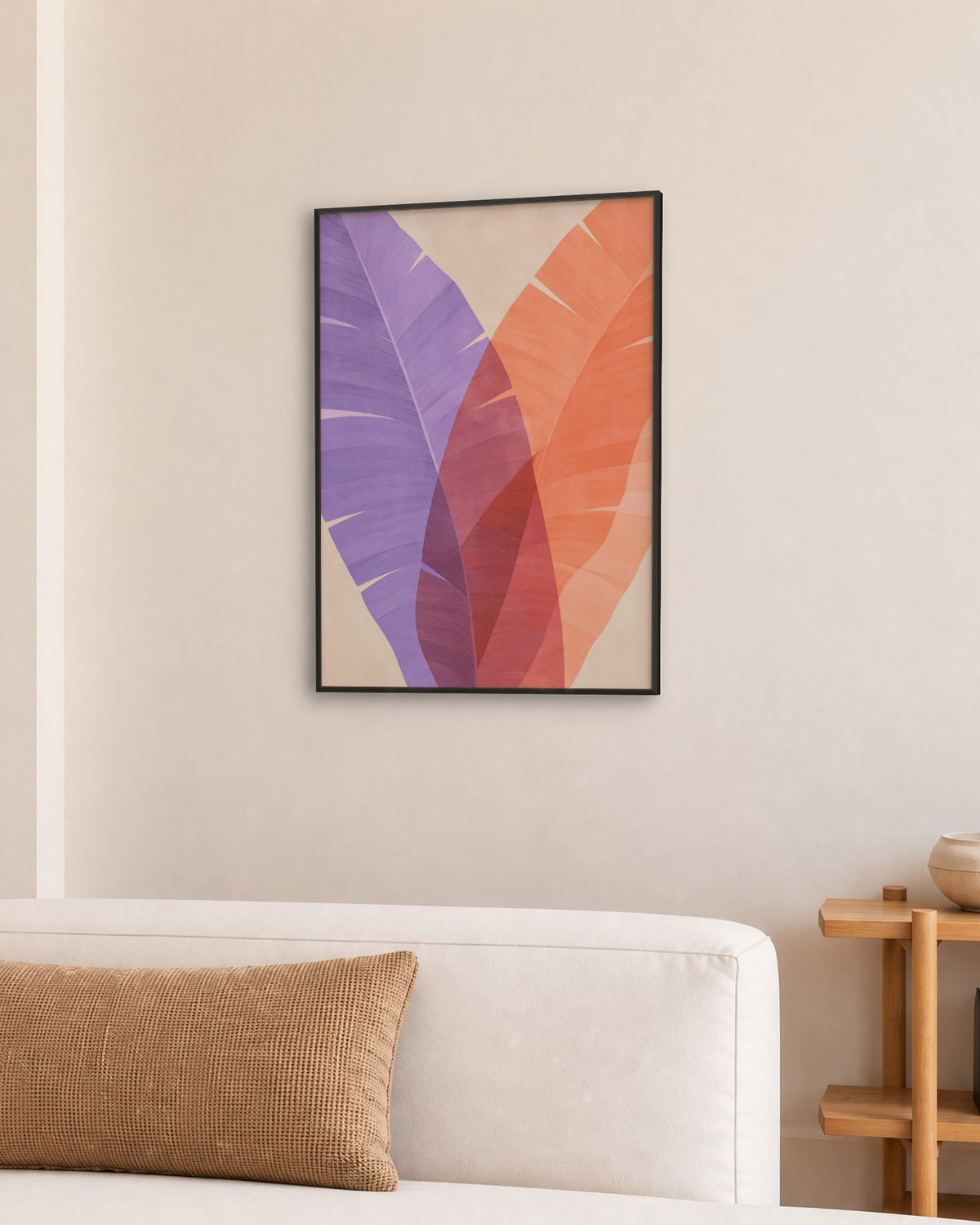 Affiche feuilles de bananier violet et corail en cadre noir dans un salon au canapé blanc et niches crème