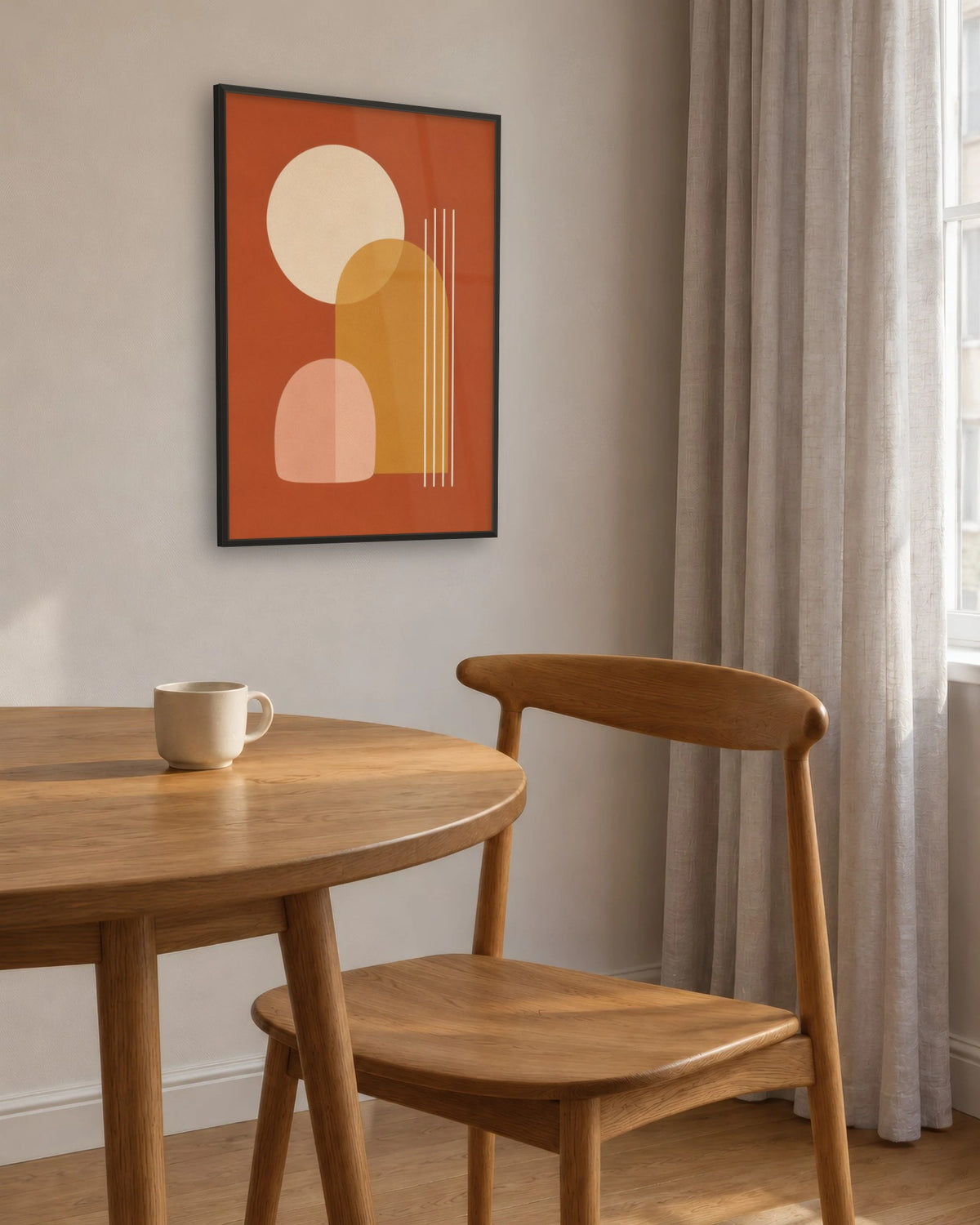 Affiche salle à manger terracotta en cadre noir au-dessus d'une table ronde en chêne