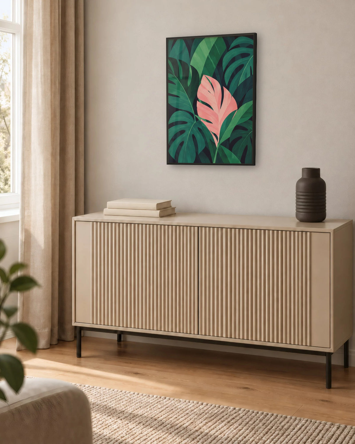 Affiche déco salon jungle vert et rose encadrée en noir au-dessus d'un buffet beige rainuré
