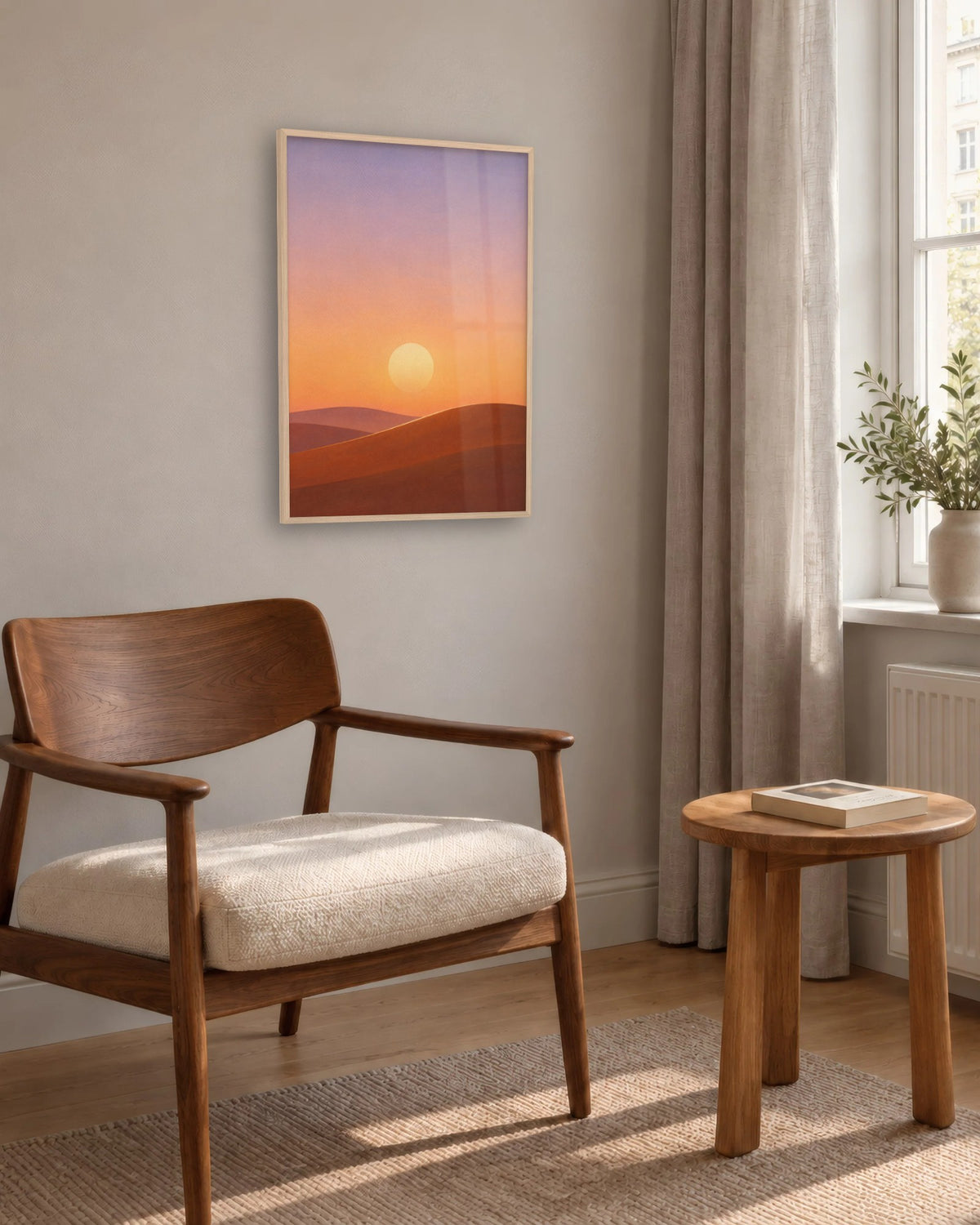 Affiche dunes et soleil couchant en cadre chêne clair au-dessus d'un fauteuil en noyer dans un coin lecture