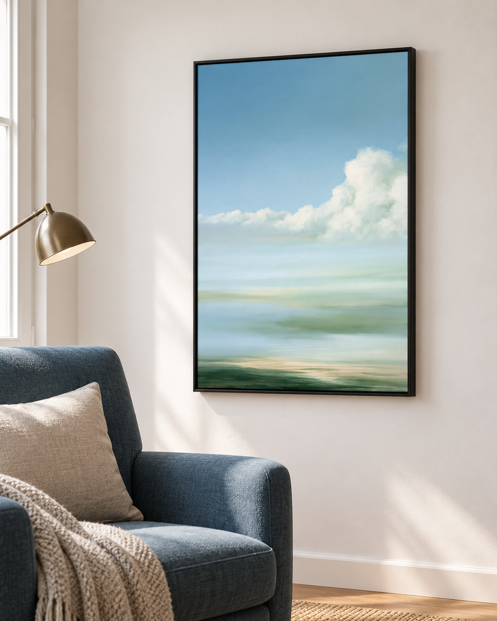 Tableau décoration murale salon en cadre noir, ciel bleu et nuage au-dessus d'un fauteuil bleu et d'une liseuse
