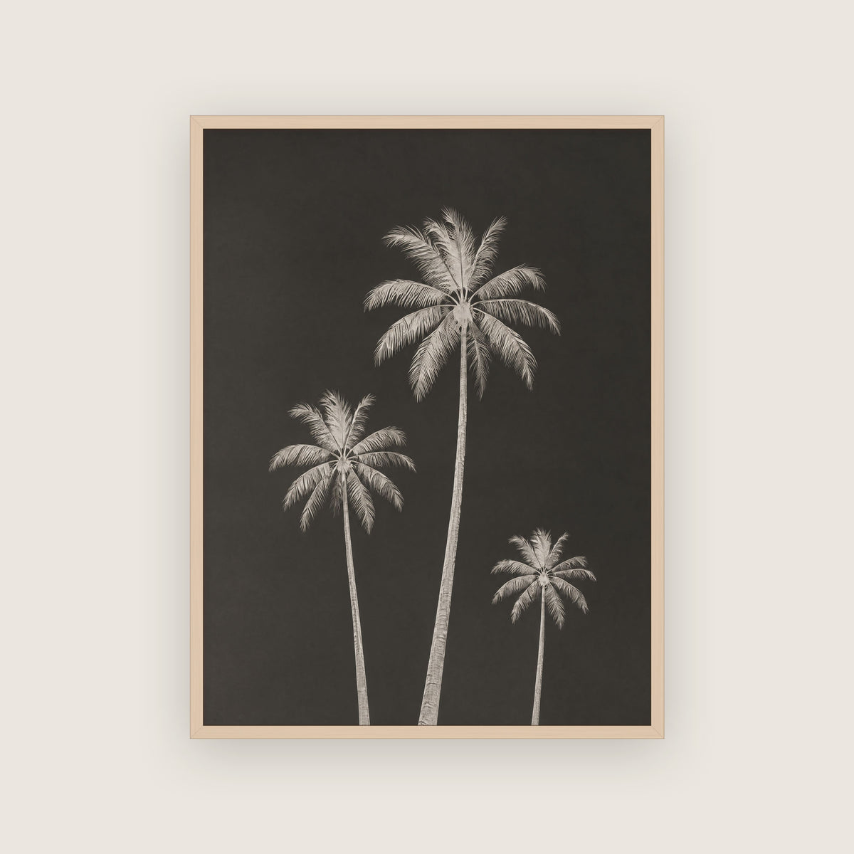 Affiche tropicale graphique dans un cadre en chêne clair, palmiers pâles sur fond noir profond