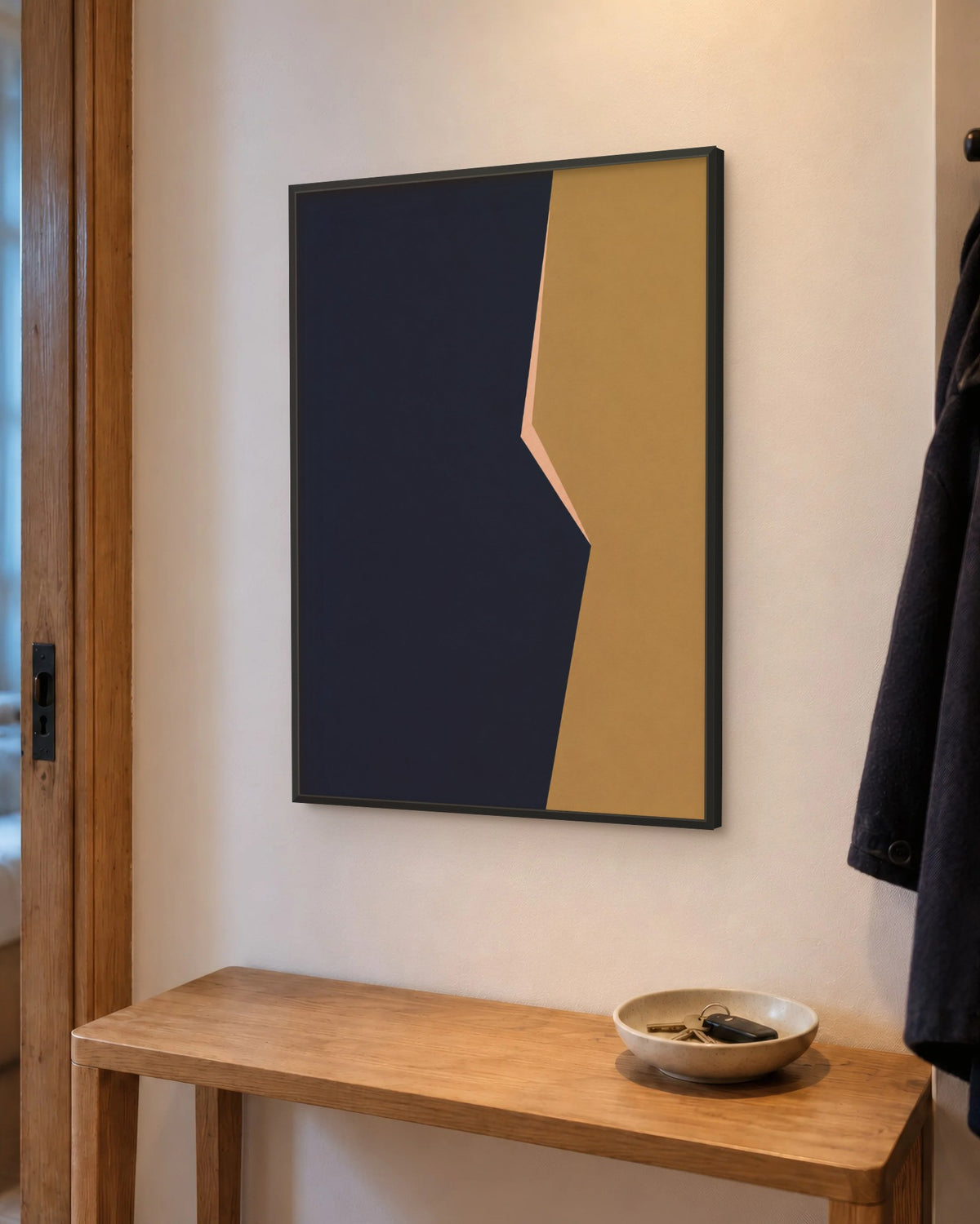 Affiche entrée minimaliste bleu marine et ocre encadrée en noir au-dessus d'une console