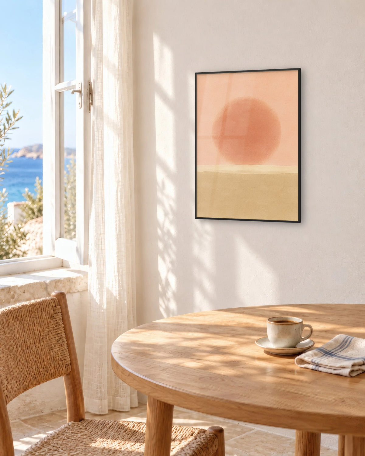 Affiche salle à manger soleil et sable encadrée en noir au-dessus d'une table face à la mer