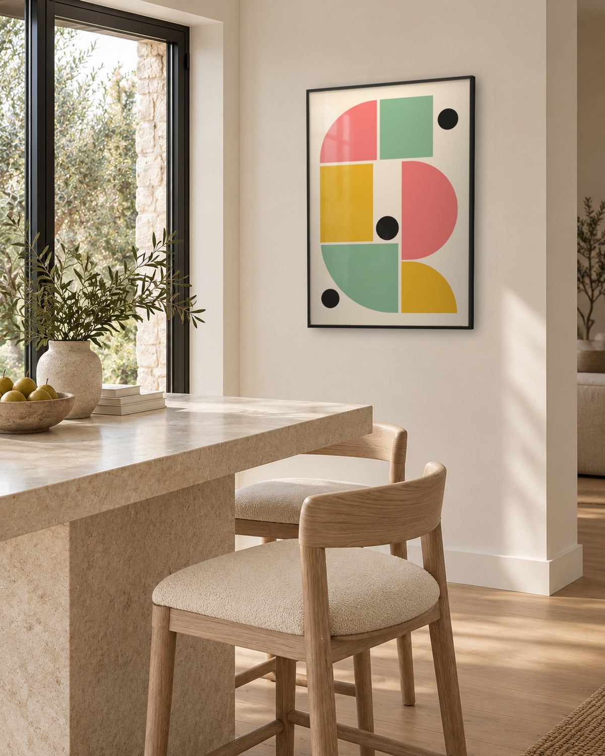 Affiche Bauhaus formes rose, jaune, vert d’eau et ronds noirs, cadre noir, cuisine à îlot en pierre beige