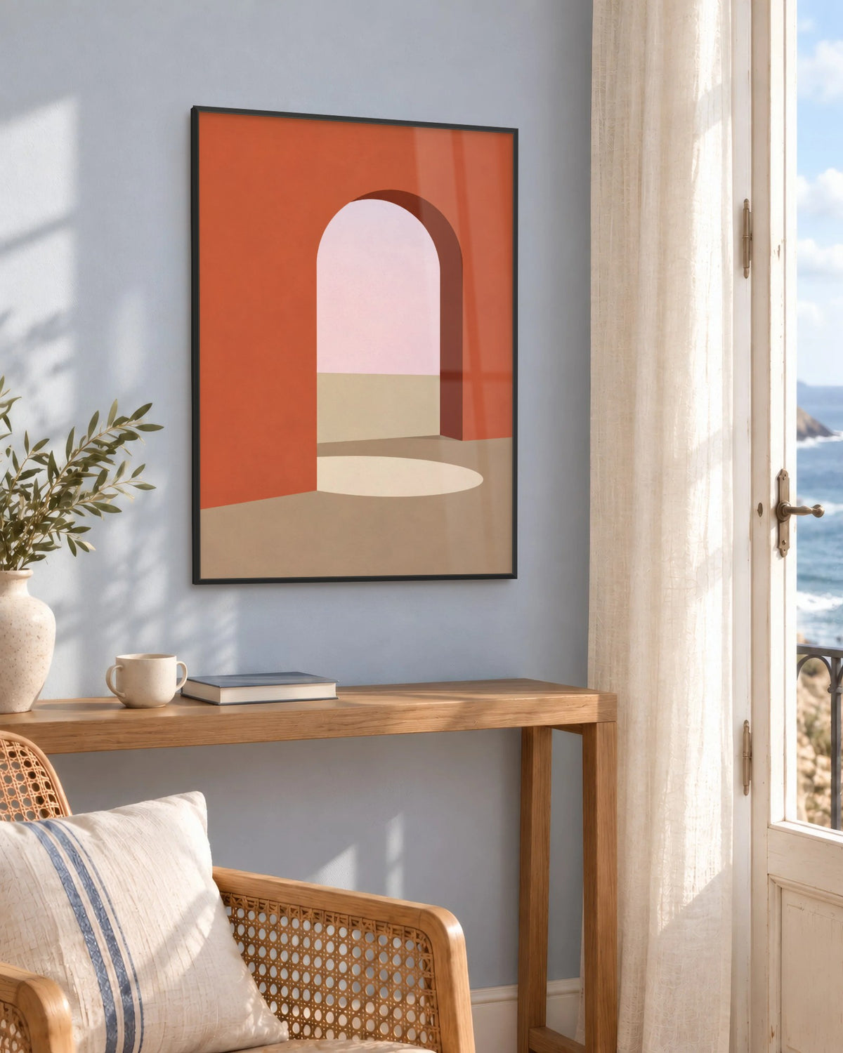 Affiche déco salon arche terracotta et rose encadrée en noir sur un mur bleu, près d'une console