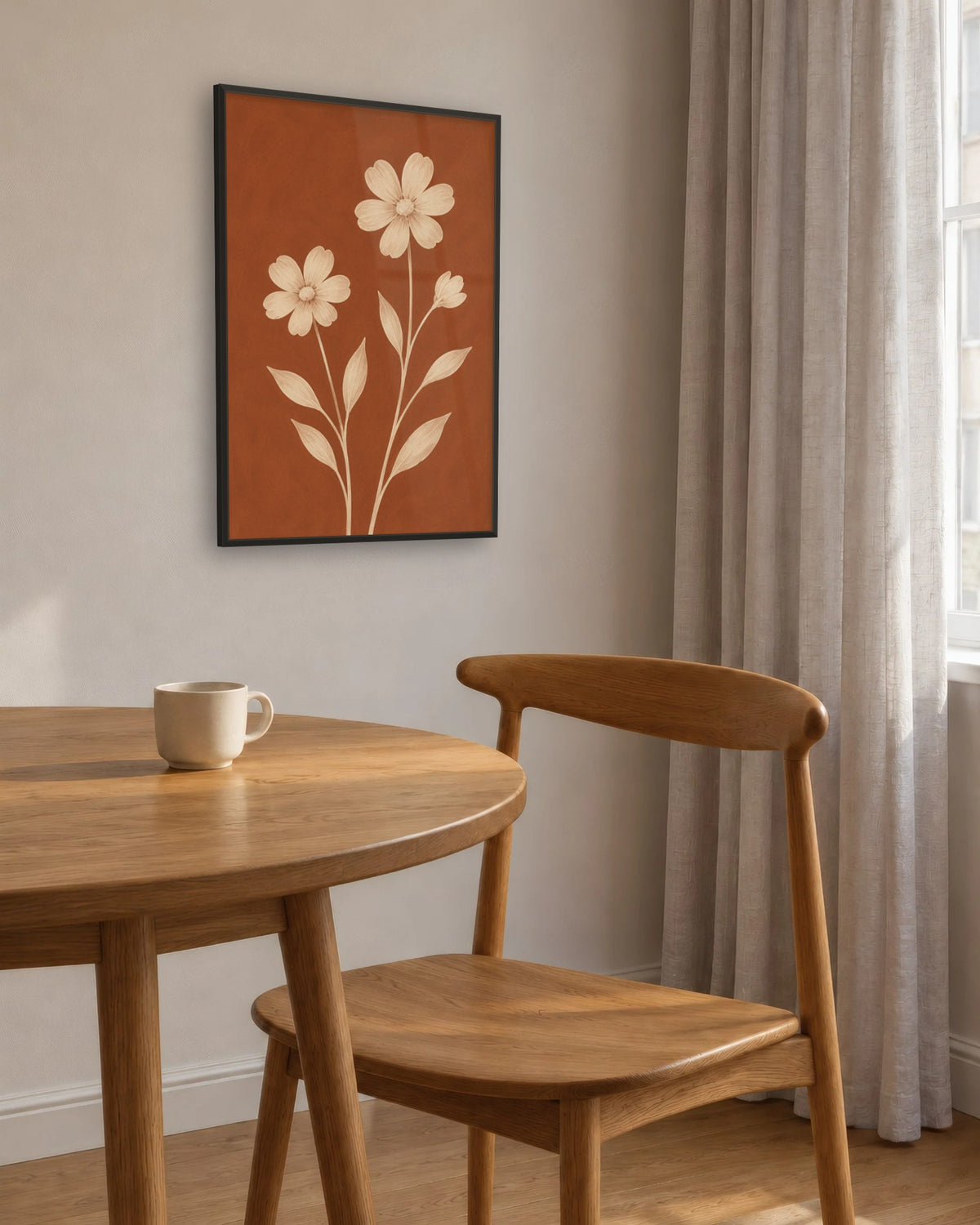 Affiche salle à manger fleurs terracotta encadrée en noir près d'une table ronde en chêne