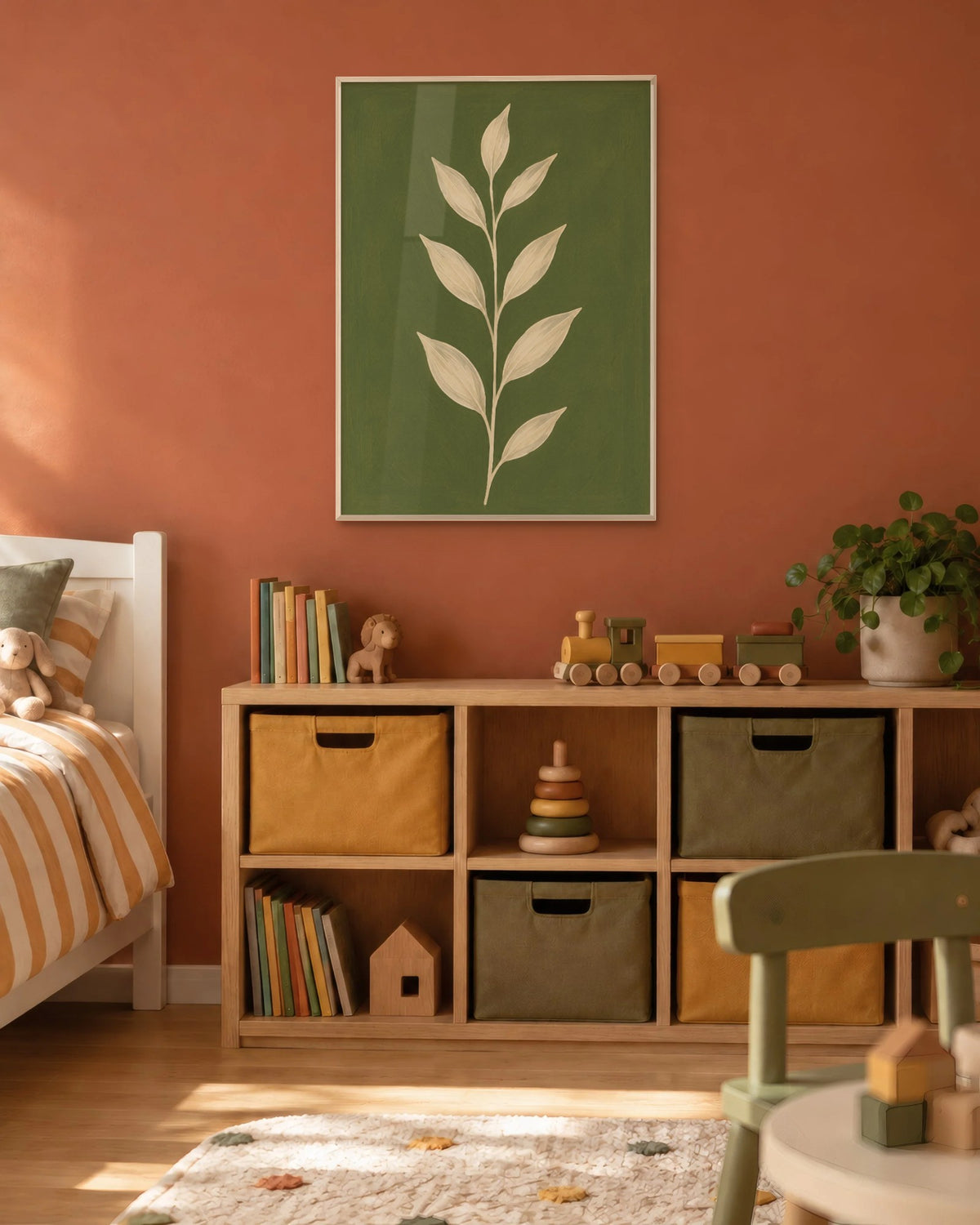 Affiche chambre d'enfant branche vert olive en cadre chêne clair sur un mur terracotta