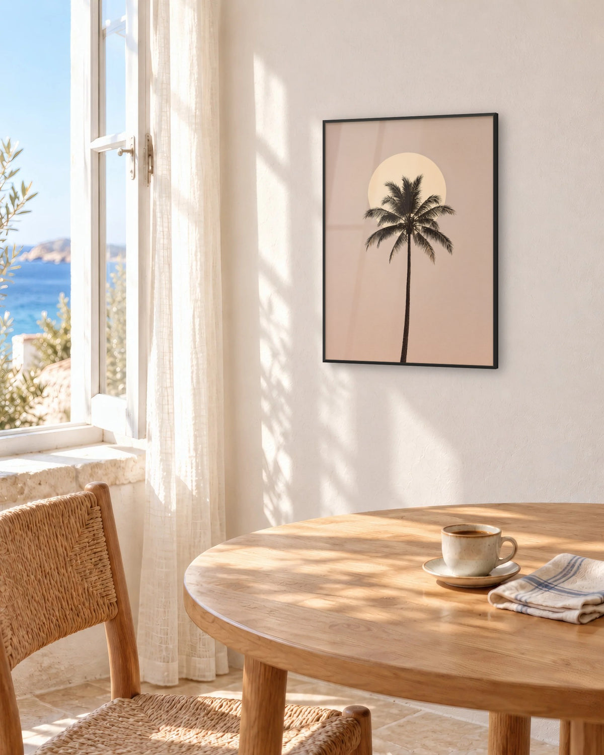 Affiche salle à manger palmier et soleil pâle encadrée en noir au-dessus d'une table face à la mer